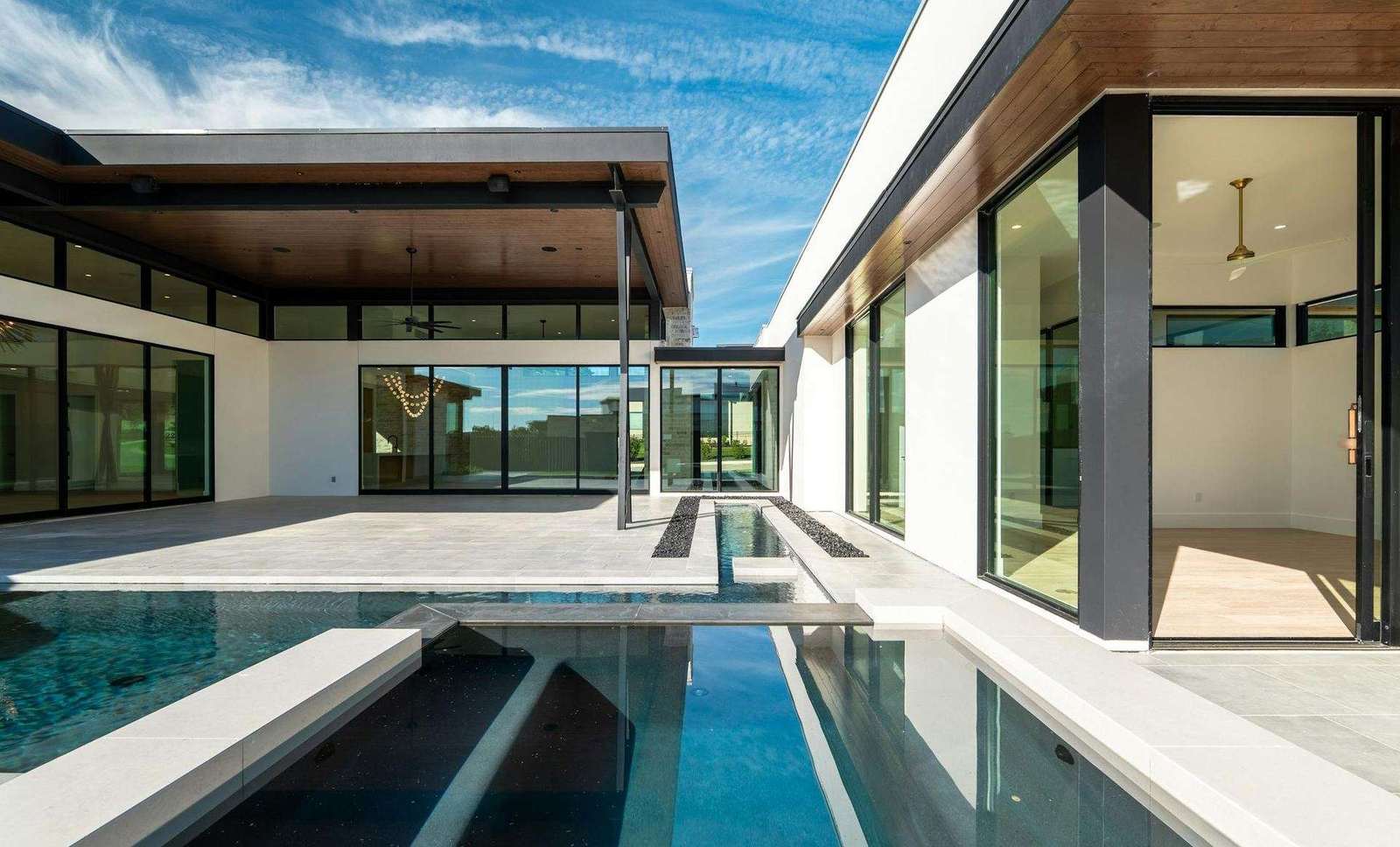 Villa contemporaine équipée de grandes baies vitrées coulissantes en aluminium, face à une piscine